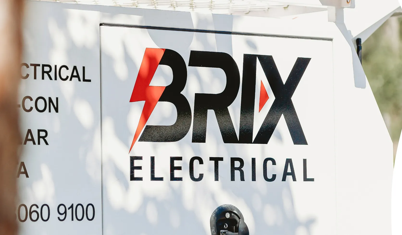 Close-up of Brix Electrical logo on a service vehicle, branding signage.