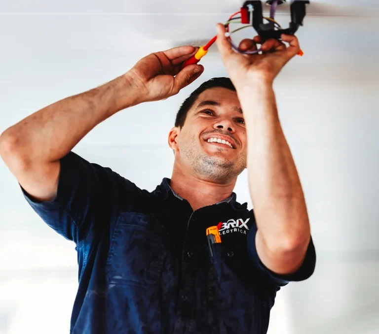 Electrician installing ceiling light wiring, showing ceiling installation work.