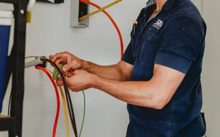 Electrician working on wiring with tools on the floor, showing on-site electrical work.