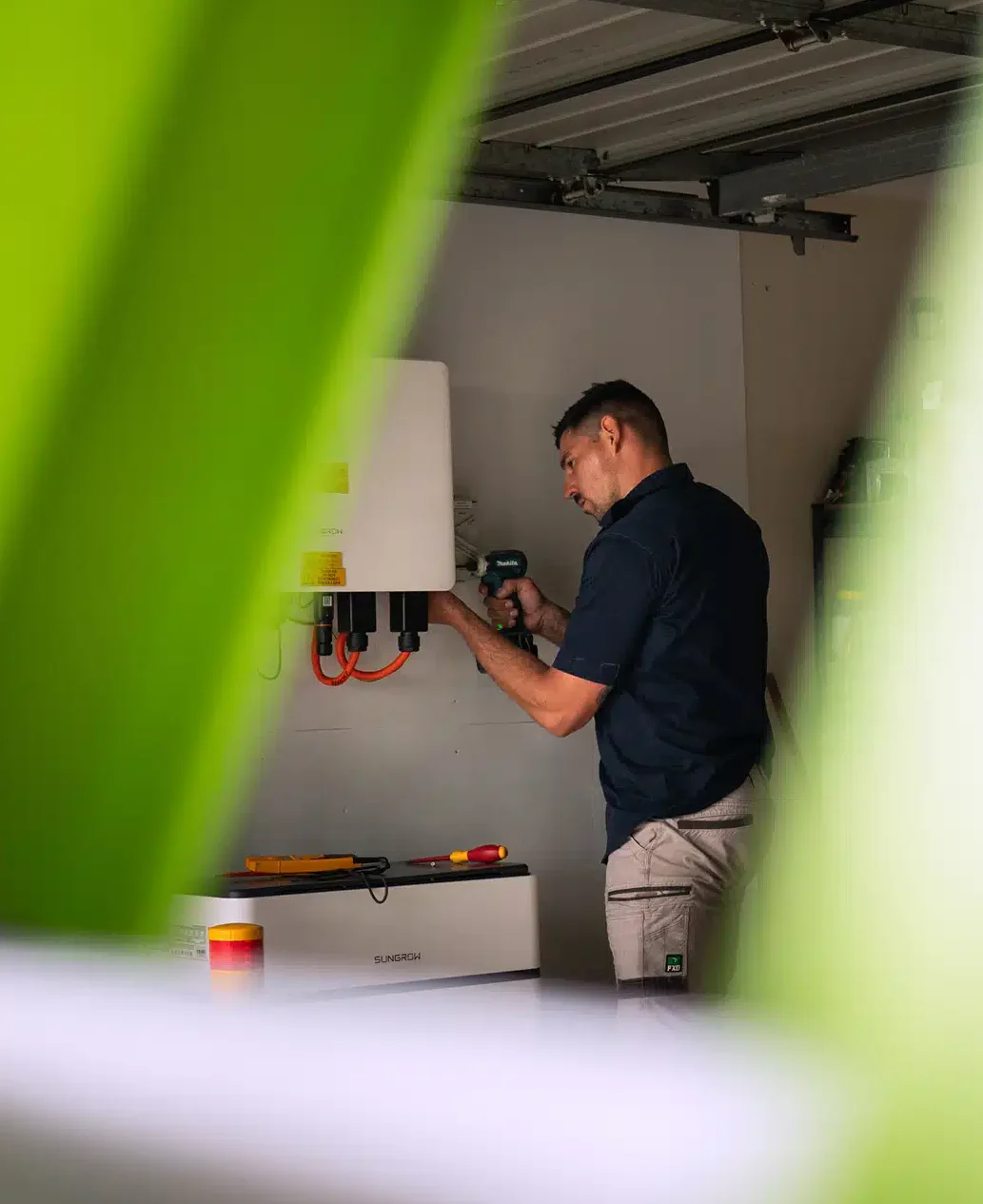 Brix Electrical & Air technician installing a Sungrow solar battery and inverter system