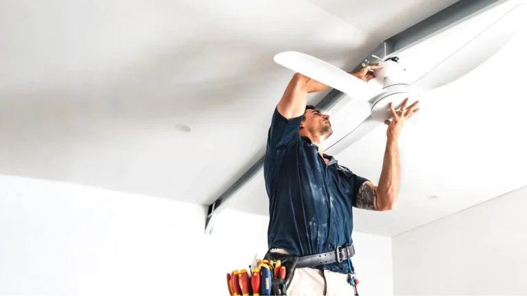 Brix Electrical & Air electrician installing a white ceiling fan in a modern home