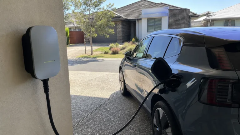 Wall-mounted home EV charger connected to an electric car in an Australian residential garage